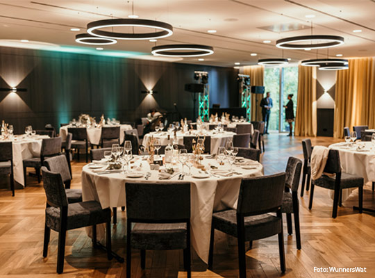 große, elegant gedeckte runde Tische im Speisesaal 